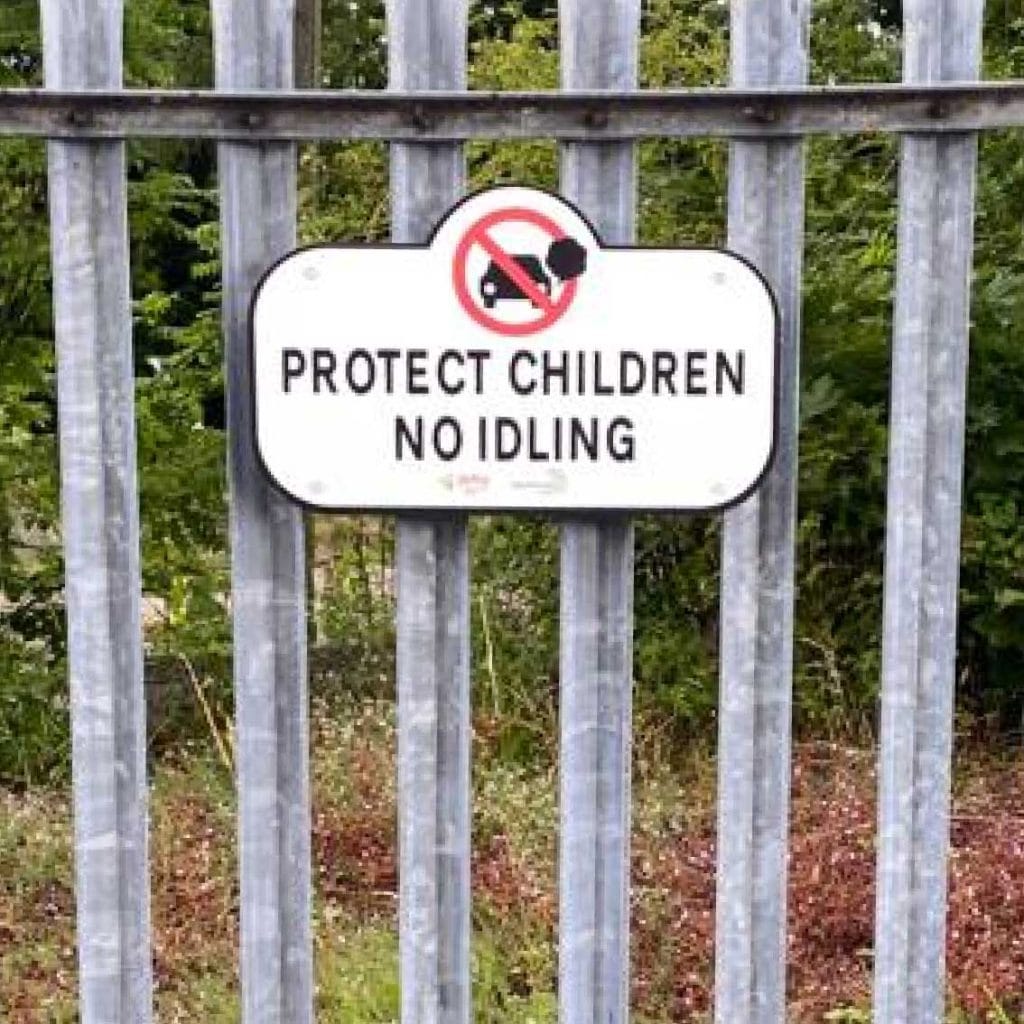School fence no vehicle idling sign